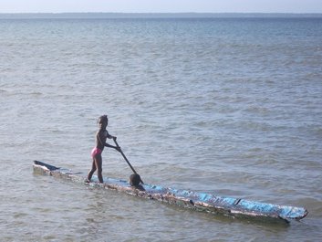 Enfants jouant avec une vieille pirogue au village d'Awas