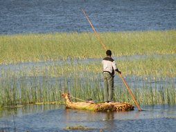 Pêcheur sur un bateau traditionnel en roseaux.