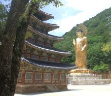 Le Grand Bouddha de Beopjusa : pour avoir une idée de sa taille, repérez les personnes près de la base. La pagode en bois, à 5 étages, mesure  22,7 m de haut.